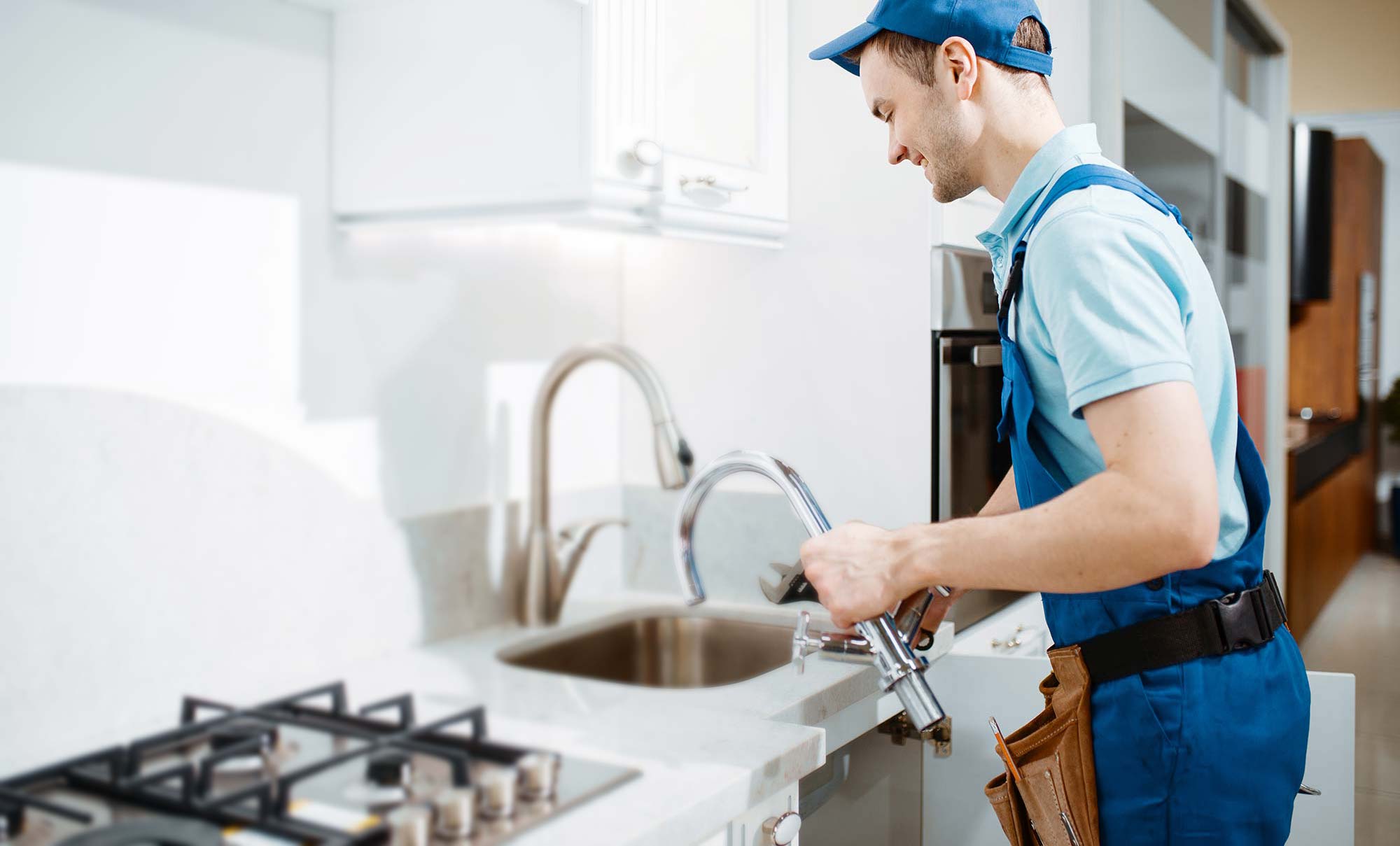 plumber-in-uniform-changes-faucet-in-the-kitchen-resize-1.jpg